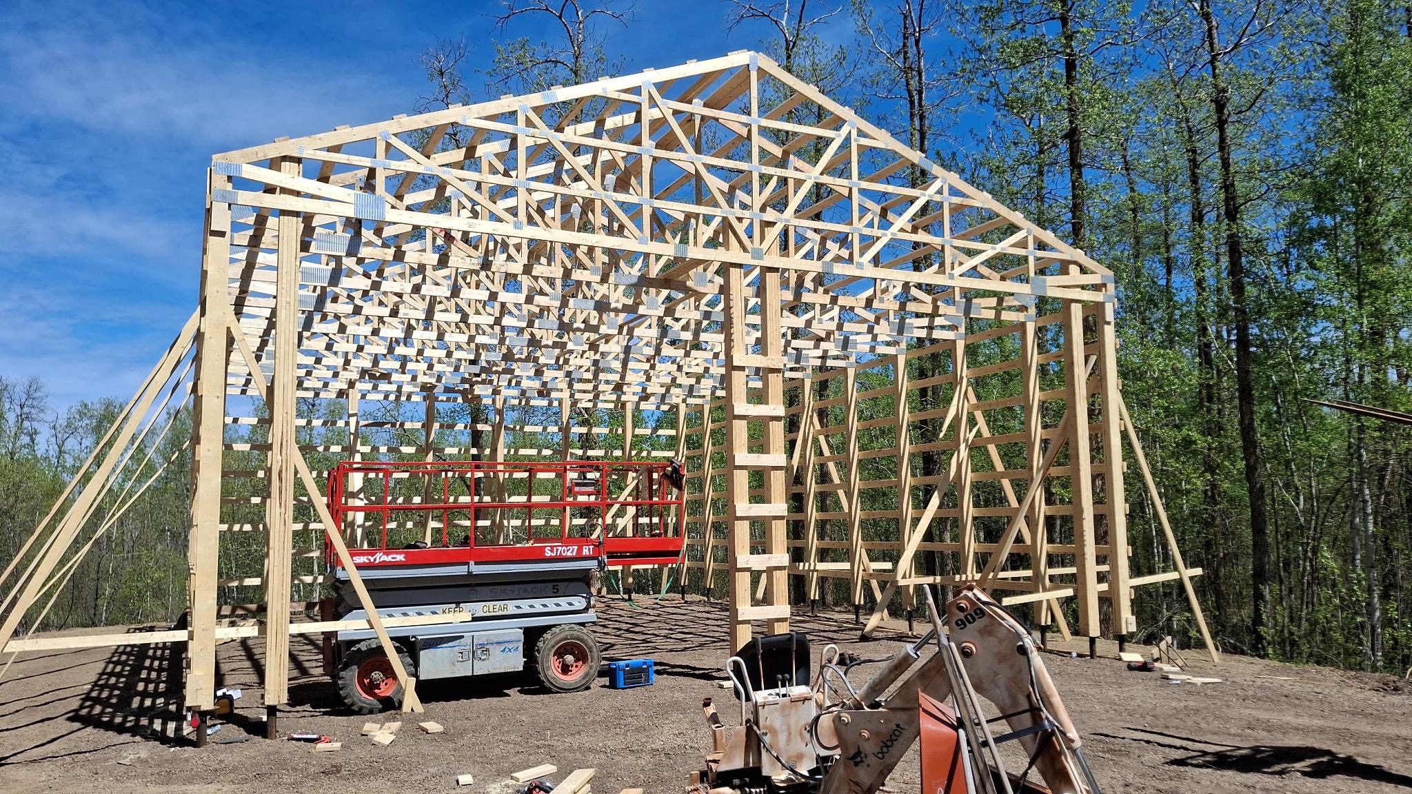 Post-frame shop framing showing wall height and roof truss construction